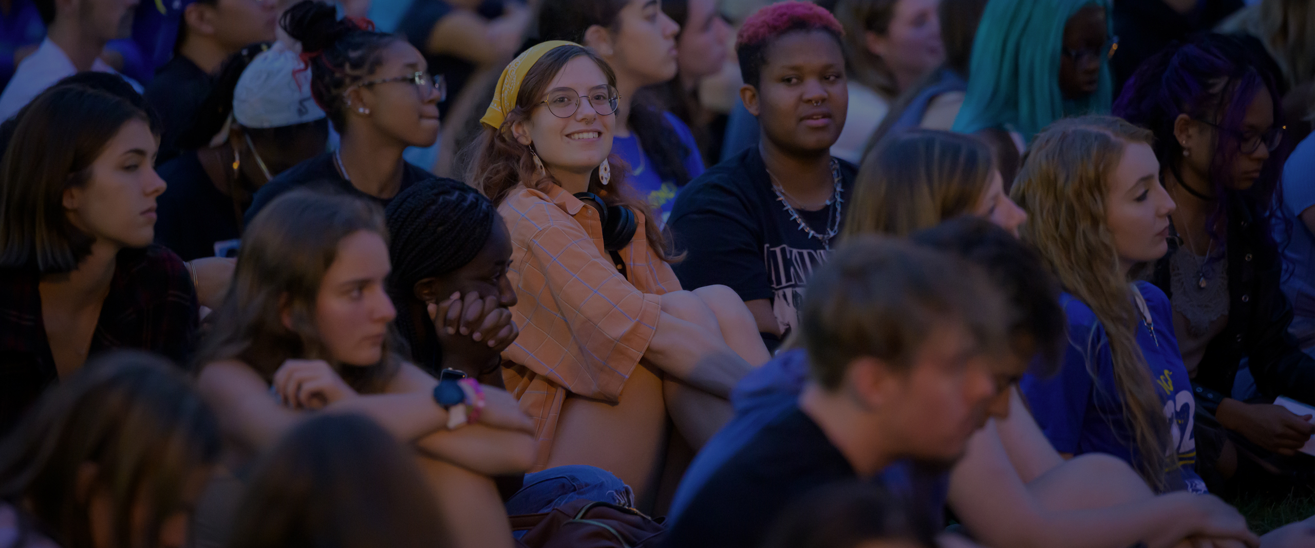 students sit on the Green awaiting the start of the Twilight Induction Ceremony