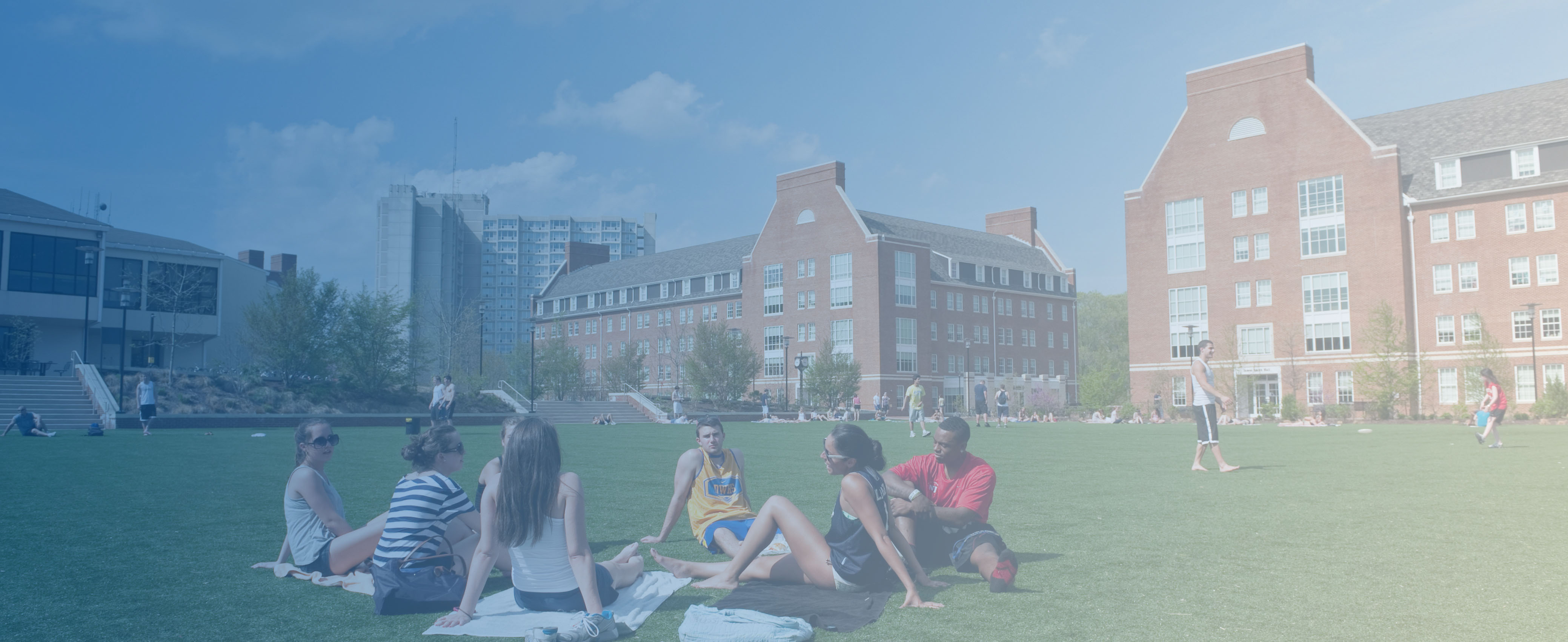 Students sit together in green common area outside Thomas McKean and James Smith