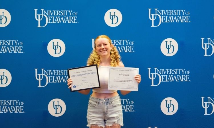 Student holding award certificate