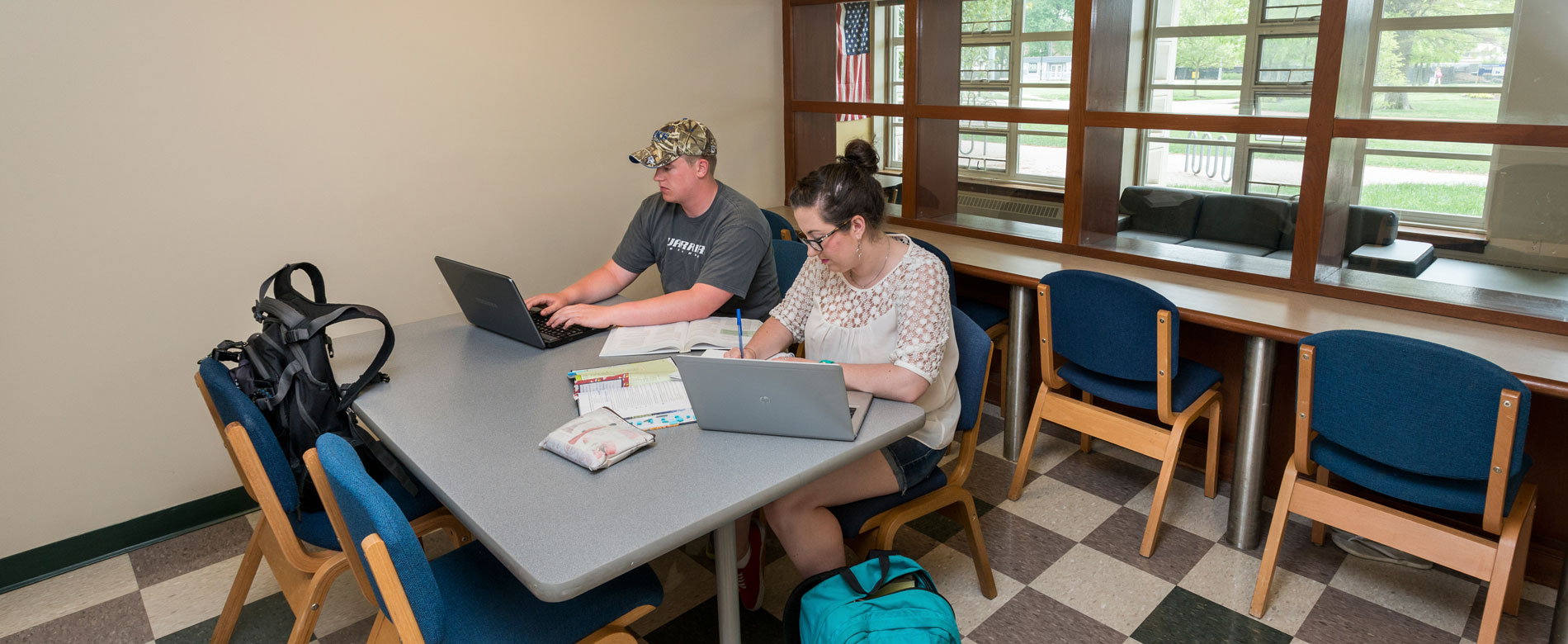 Students study together at a table in a lounge area