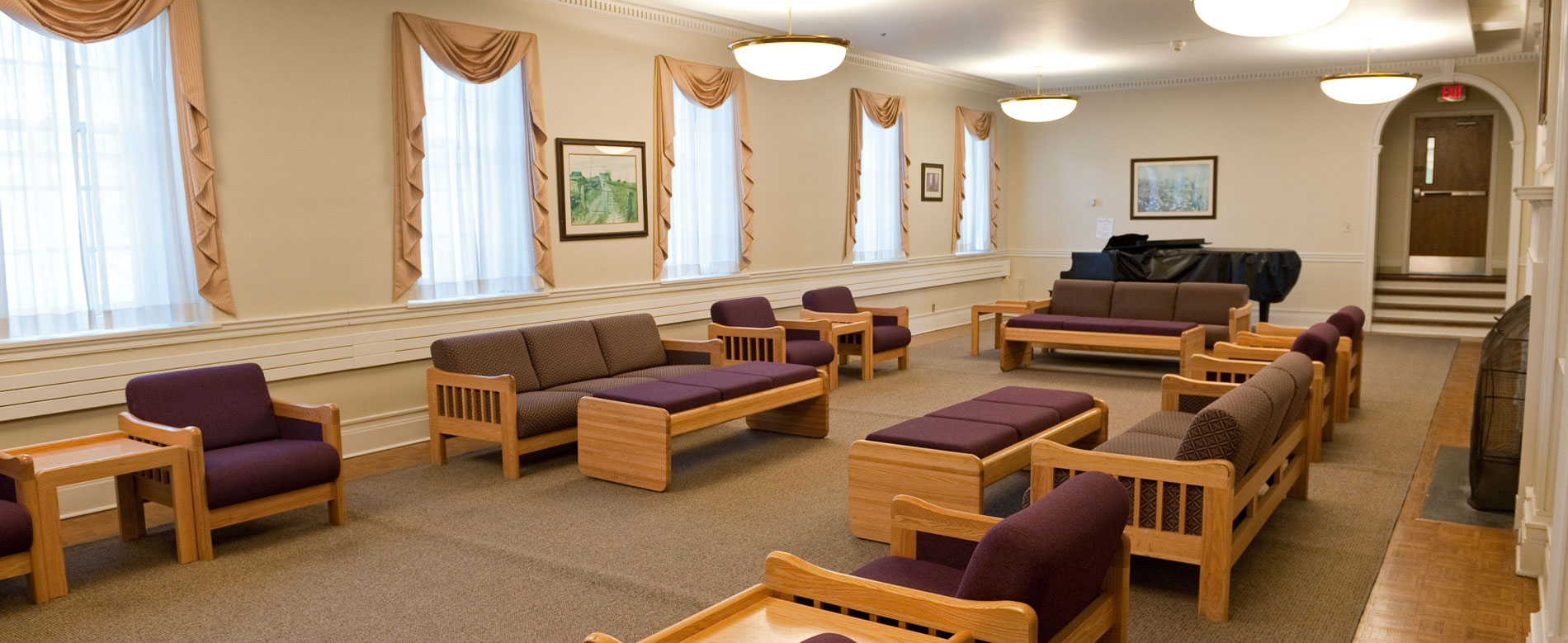 Lounge area with sofas, footrests and a piano on one end