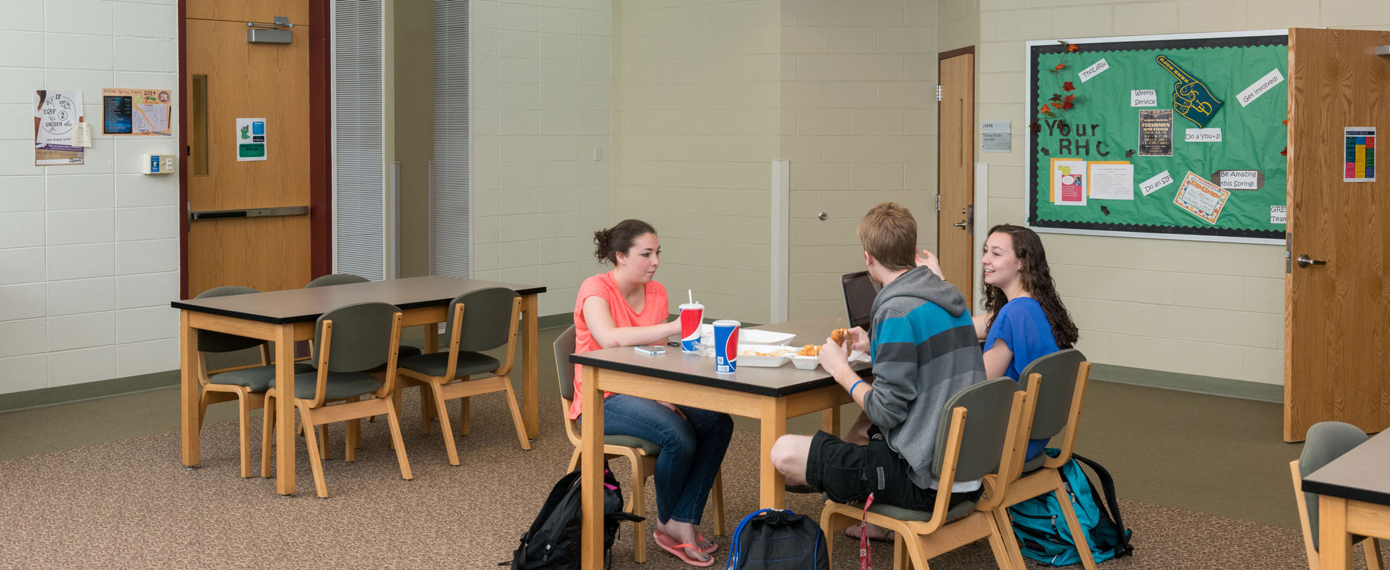 Students eating and working in a Russell Hall lounge space