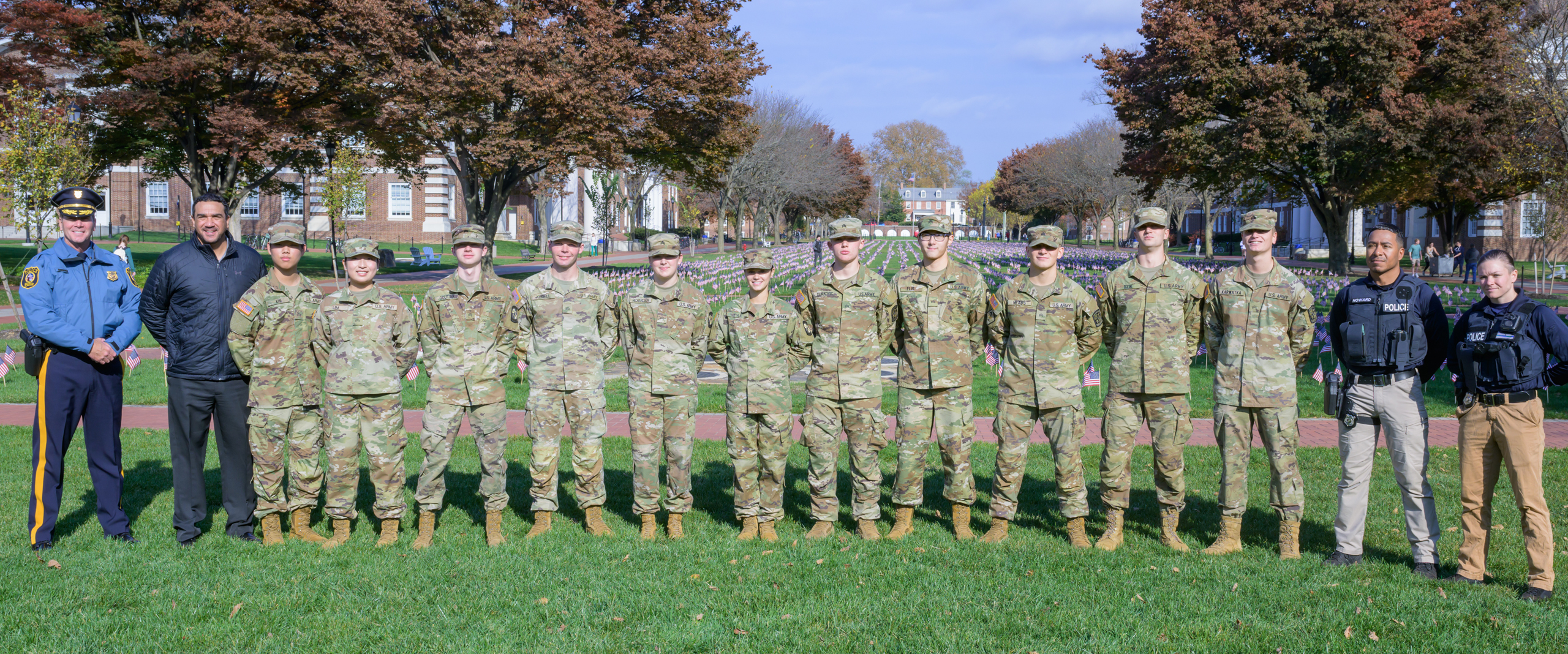 a row of military members in uniform lined up on the Green