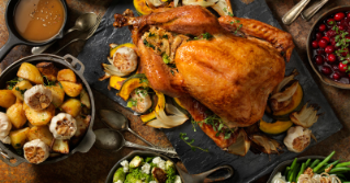 A photo of a cooked turkey surrounded by various side dishes