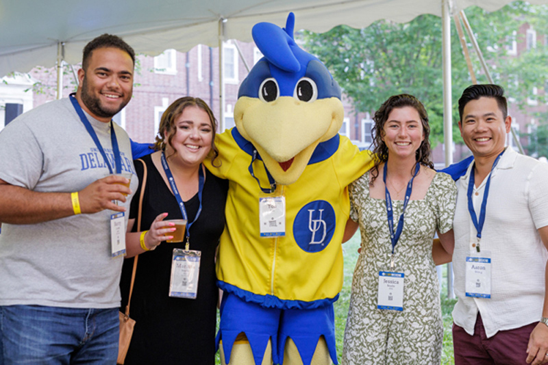 Alumni pose with their favorite feathered friend, YoUDee, at the Friday night Beer Garden on the North Green.