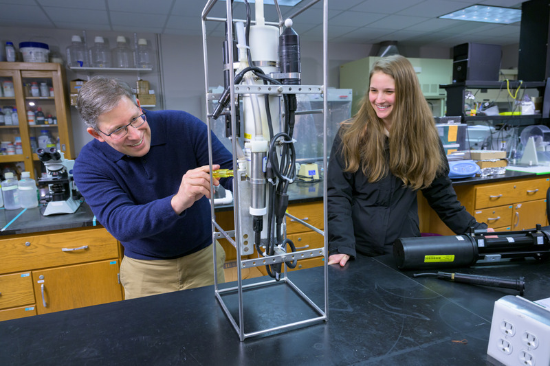 Dr. Cohen and student in lab examining equipment