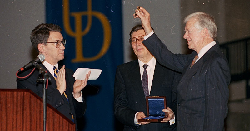 Former President Jimmy Carter receiving the Karl W. Böer Solar Energy Medal of Merit he had just received at the University of Delaware in 1993 in recognition of his promotion of renewable energy, with UD President David Roselle and Böer 