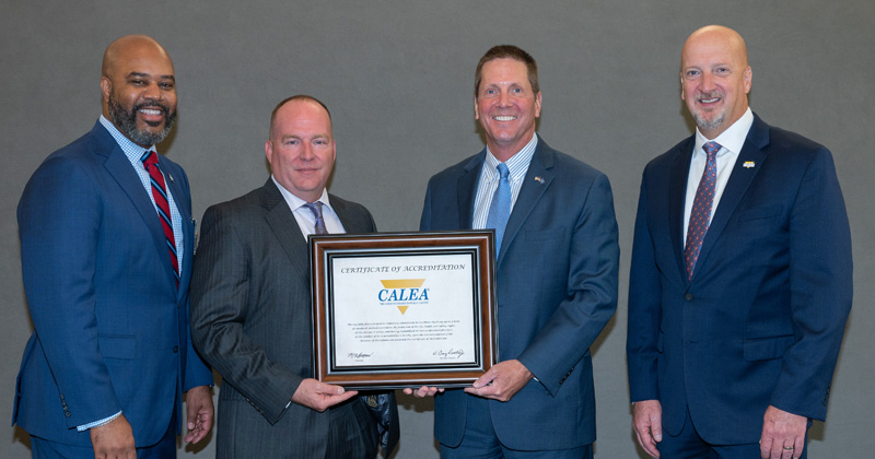 University of Delaware Chief of Police Pat Ogden (third from left) receives the department’s re-accreditation certificate at CALEA’s annual conference in November 2024. Chief Ogden is seen with, from left, CALEA Commission chairman Marlon Lynch; UD Police Sergeant Jeff Gates; and CALEA executive director Craig Hartley.