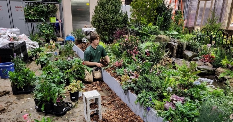 Jackson Fox, a University of Delaware student and member of the UD Philadelphia Flower Show Club, works on the installation ahead of the Philadelphia Flower Show. 