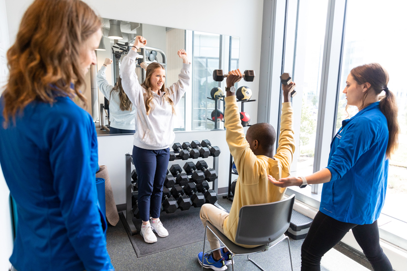 Students in adaptive physical activity class with an athlete