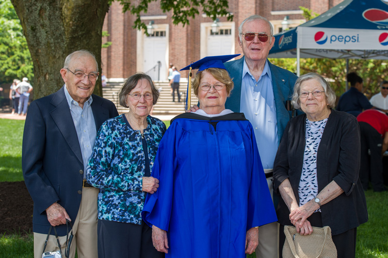 One of UD's newest graduates, Carol White, 81, stands with with her family on either side at Commencement in May 2018. 