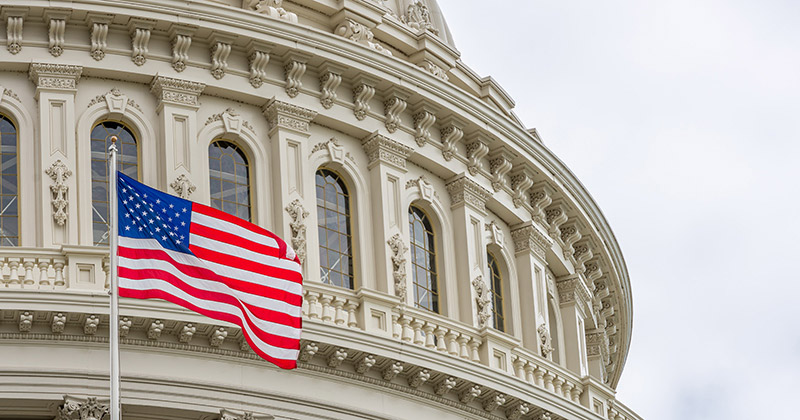 US Capitol building with waving American flag in Washington DC