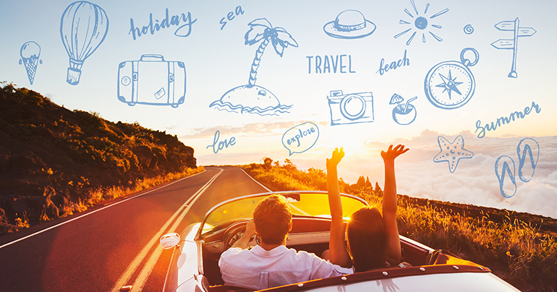 Happy Couple Driving on Country Road into the Sunset in Classic Vintage Sports Car 