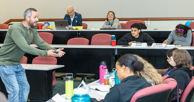 Decorated former Marine Dennis Derr engages with students at the SYLP Economics Summer Camp in June. 