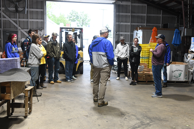 Bobby Fifer (far right), inside the packing and sorting barn, explains his role as production manager of the Delaware family farm. Bobby Fifer (far right), inside the packing and sorting barn, explains his role as production manager of the Delaware family farm.