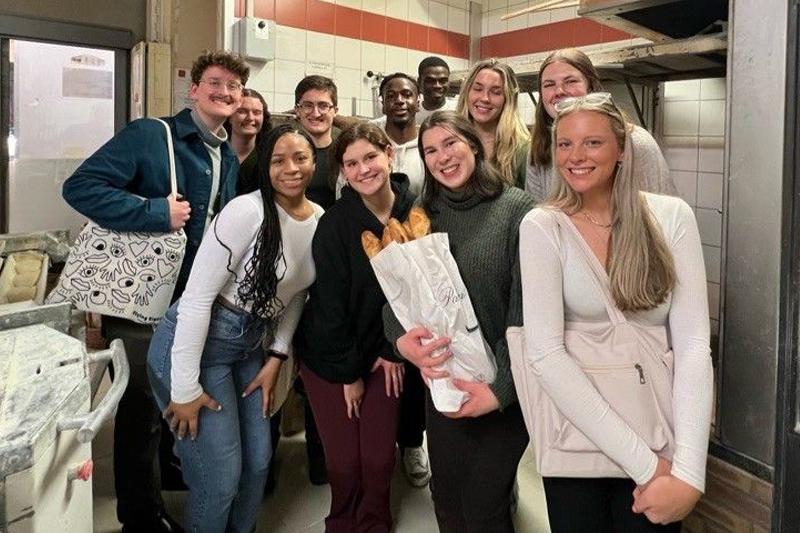 A group of Winter 2023 Paris biological sciences students pose with their freshly made baguettes. 