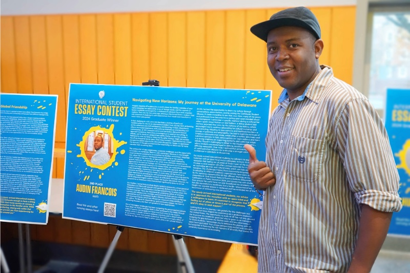 Each year, the International Student Essay Contest provides international students with a platform to share their perspectives with the greater University community. Pictured is Audin Francois, second place winner in the graduate student category, with a poster of his essay on display in Trabant University Center during International Education Week.