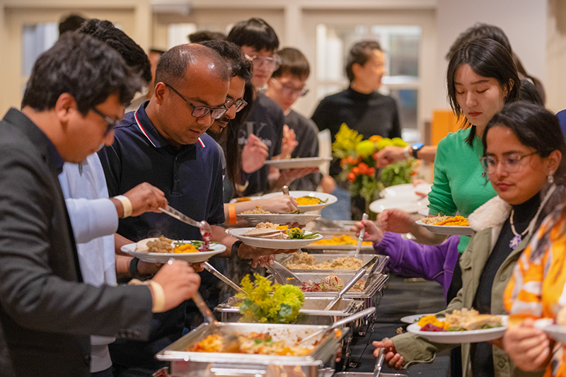 International students, scholars and their families enjoy a traditional Thanksgiving dinner with turkey and all of the fixings at an event hosted by the Center for Global Programs and Services.