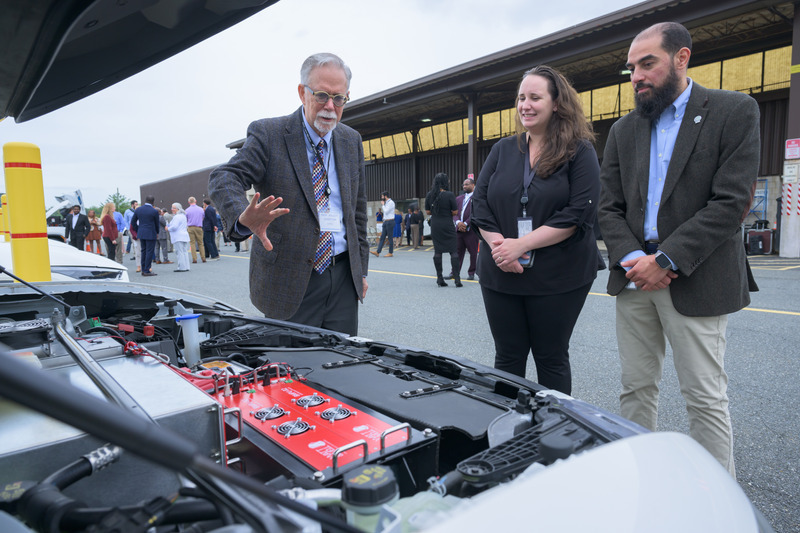 University of Delaware Professor Willett Kempton (left) explains the vehicle-to-grid (V2G) technology he pioneered at a demonstration event with project partner Delmarva Power and others in Newark, Delaware held during National Drive Electric Week.