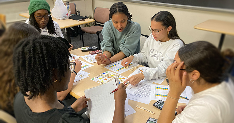 Students in Assistant Professor Lauren Genova’s general chemistry class discuss possible moves while playing a quantum number board game.