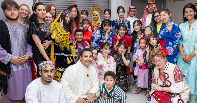 Students and staff gathered together in various cultural attire.