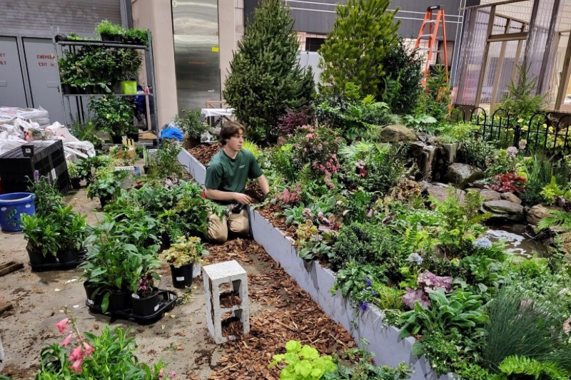 Jackson Fox, a University of Delaware student and member of the UD Philadelphia Flower Show Club, works on the installation ahead of the Philadelphia Flower Show. 