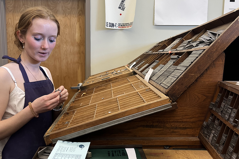 Cami Zabowski selects letter tiles to use in the letterpress during the capstone course ENGL480: From Ink to AI: Literature in the Makerspace. Cami Zabowski selects letter tiles to use in the letterpress during the capstone course ENGL480: From Ink to AI: Literature in the Makerspace.